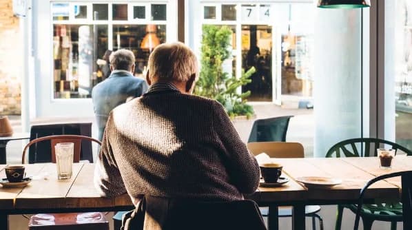An older man seated at a kitchen table